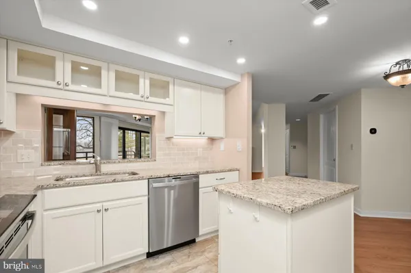 a kitchen with granite countertop kitchen island a sink appliances and cabinets