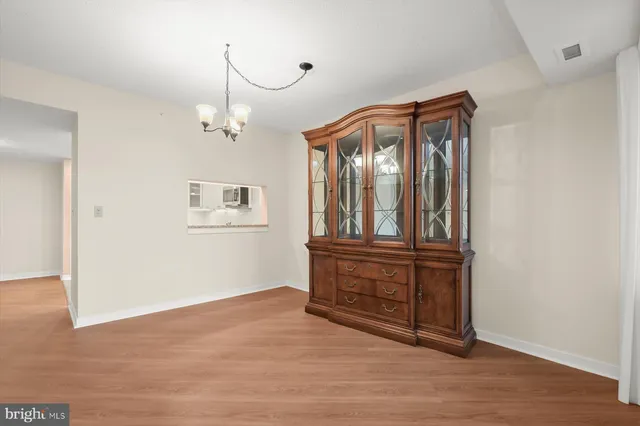 a view of a hallway with wooden floor and cabinet