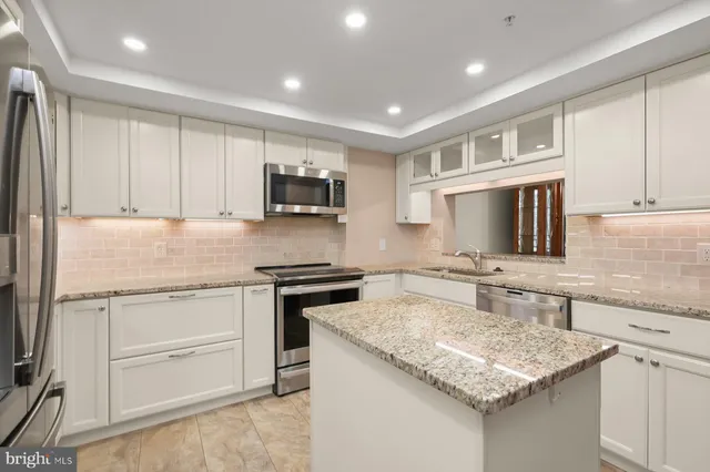 a kitchen with kitchen island granite countertop a stove sink and microwave