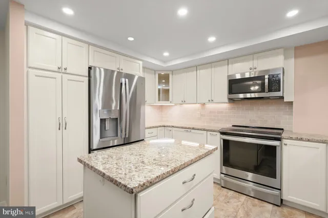 a kitchen with kitchen island a sink stove and refrigerator