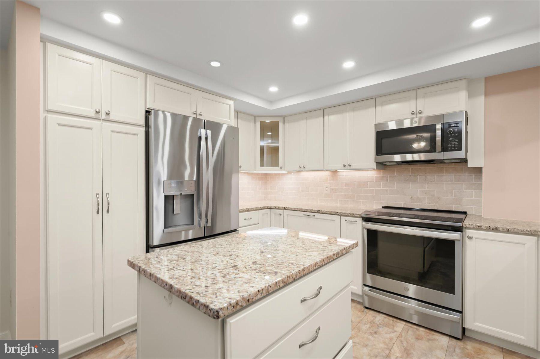10001 Windstream Drive, Unit 404 Columbia, MD 21044 - Photo 19 of 51 a kitchen with kitchen island a sink stove and refrigerator