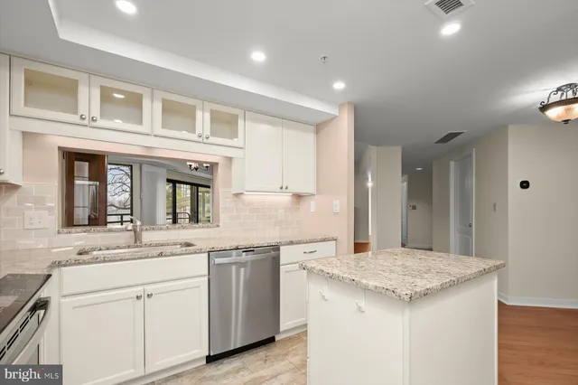 a kitchen with granite countertop kitchen island a sink appliances and cabinets