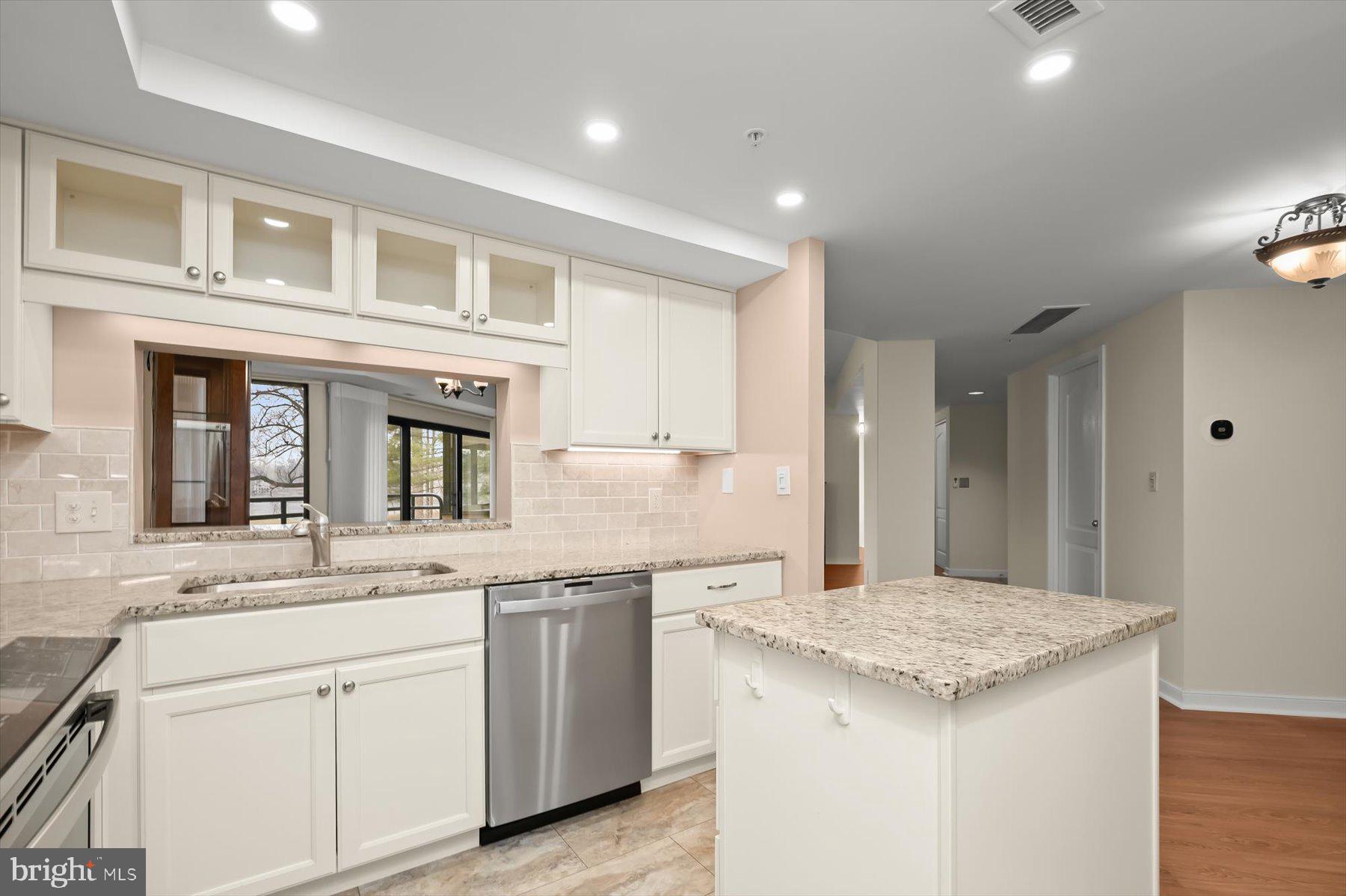 10001 Windstream Drive, Unit 404 Columbia, MD 21044 - Photo 21 of 51 a kitchen with granite countertop kitchen island a sink appliances and cabinets