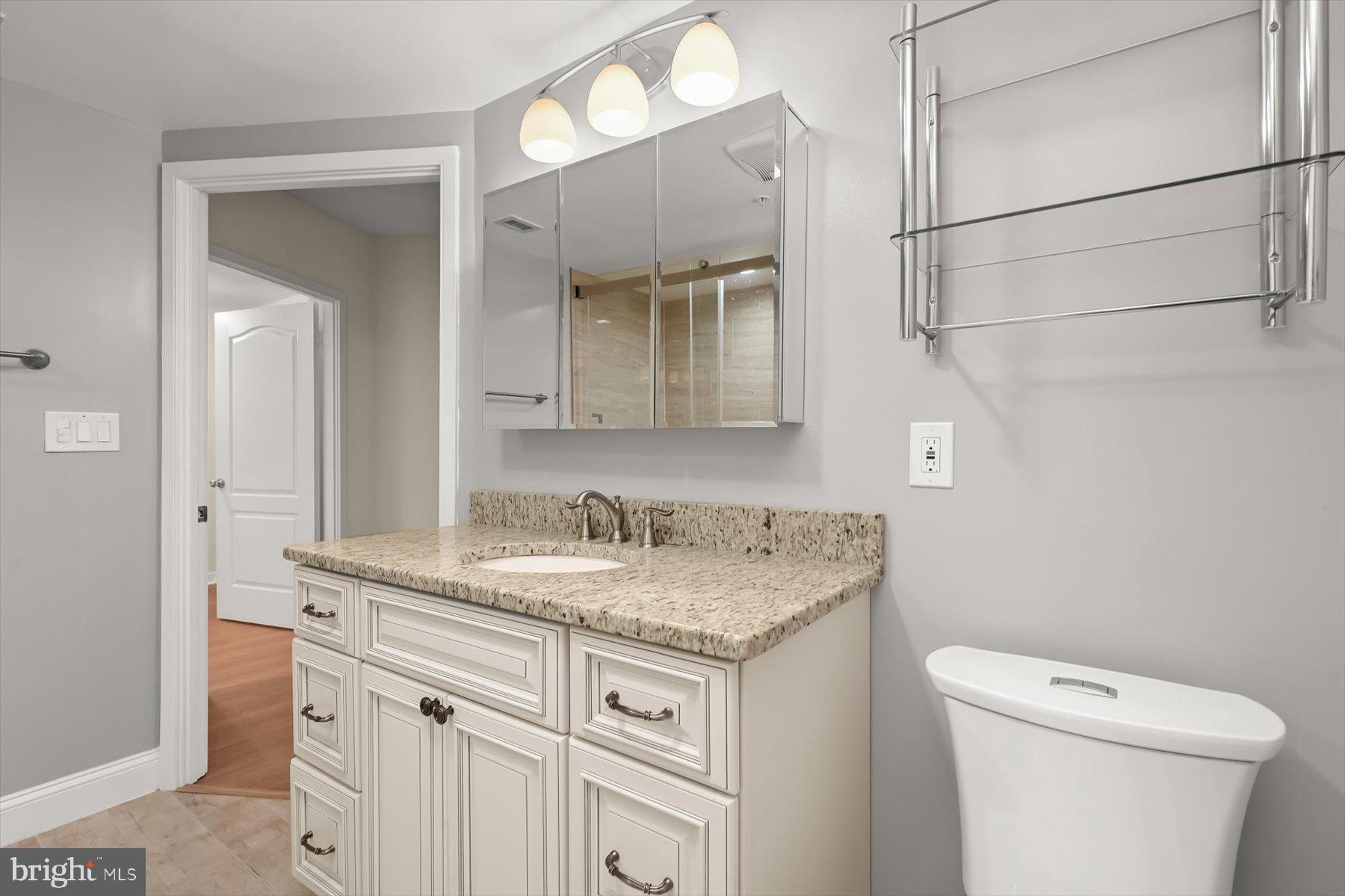 10001 Windstream Drive, Unit 404 Columbia, MD 21044 - Photo 30 of 51 a bathroom with a granite countertop sink and a toilet
