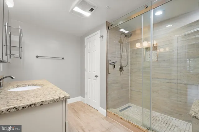 a bathroom with a granite countertop sink a shower and a mirror