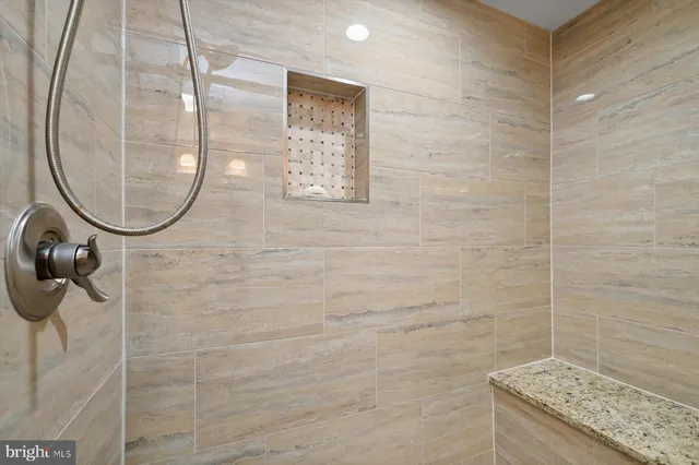 a bathroom with a granite countertop shower a mirror and a sink