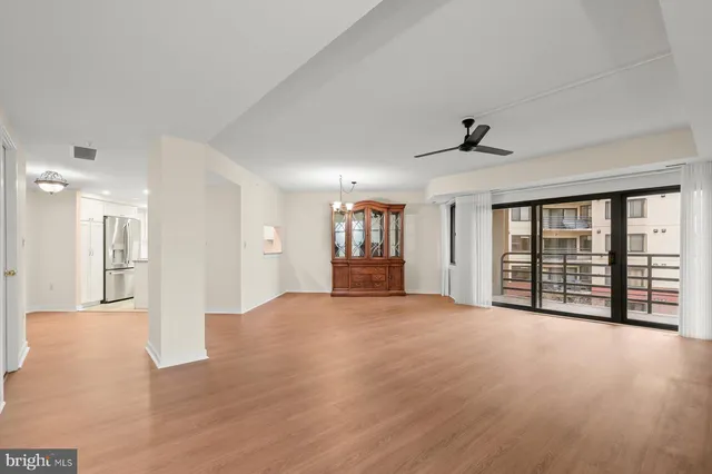 a view of an empty room with window and wooden floor