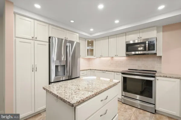 a kitchen with kitchen island a sink stove and refrigerator