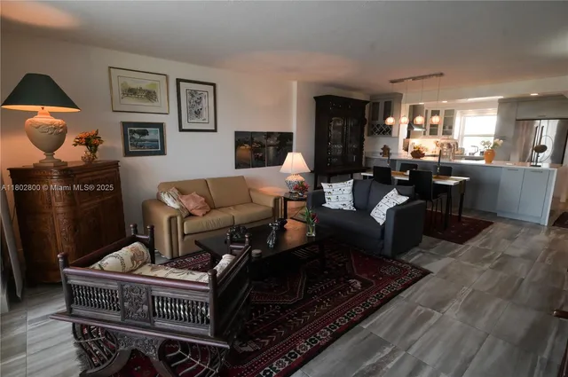 a living room with furniture a rug and kitchen view