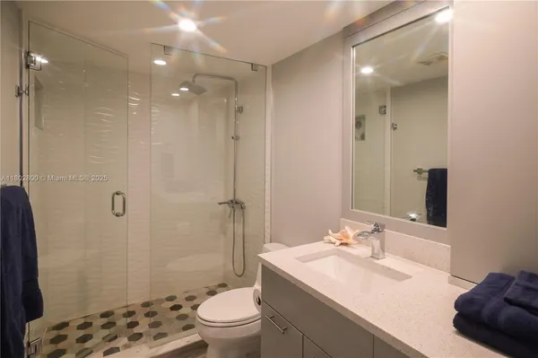 a bathroom with a sink toilet a mirror and shower