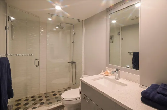 a bathroom with a sink toilet a mirror and shower