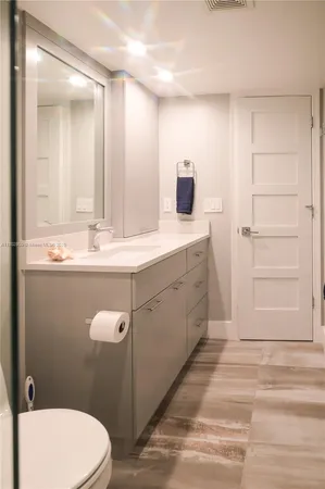 a bathroom with a sink a toilet a shower and a mirror