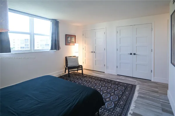 a bedroom with a bed chair and a window
