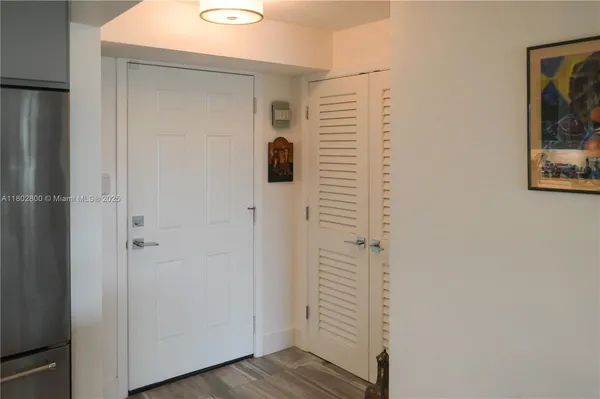 a view of a hallway with wooden floor and cabinets