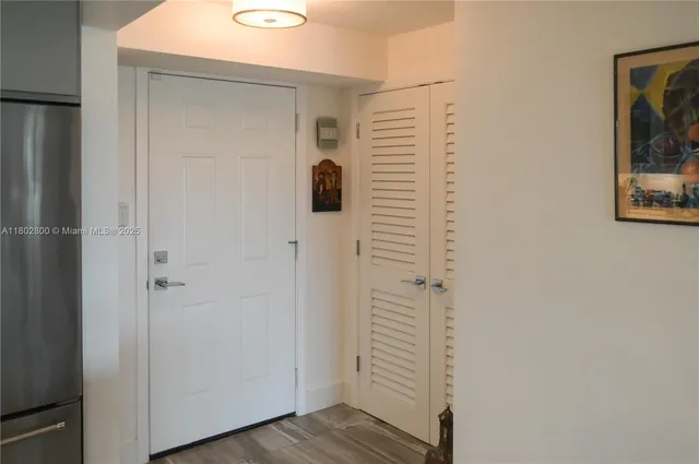 a view of a hallway with wooden floor and cabinets