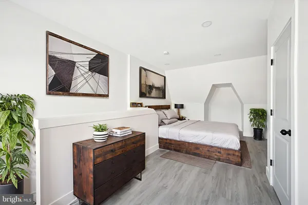 a spacious bedroom with a bed and a painting on the wall