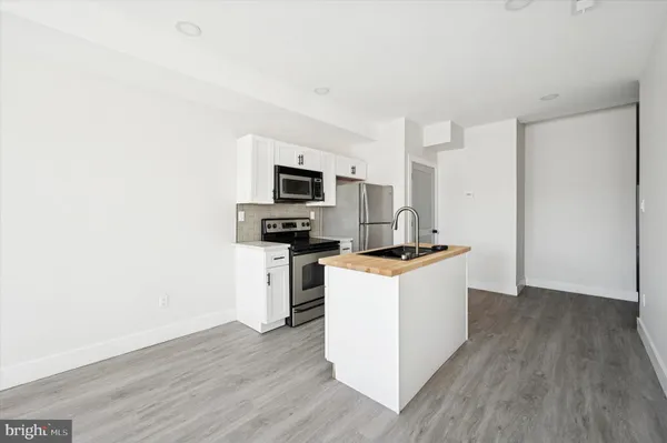 a kitchen with wooden floor and white appliances