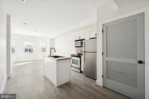 a kitchen with stainless steel appliances a refrigerator and a stove top oven
