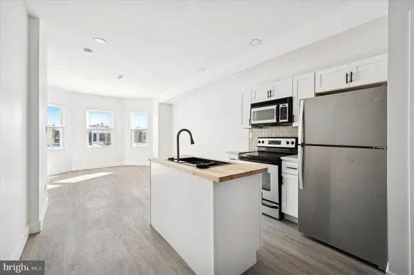 a kitchen with stainless steel appliances granite countertop a refrigerator stove a sink and dishwasher with wooden floor