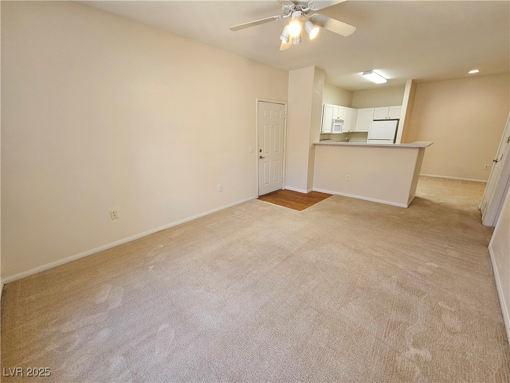9000 South Las Vegas Boulevard, Unit 1176 Las Vegas, NV 89123 - Photo 12 of 26 Unfurnished living room featuring light carpet and a ceiling fan