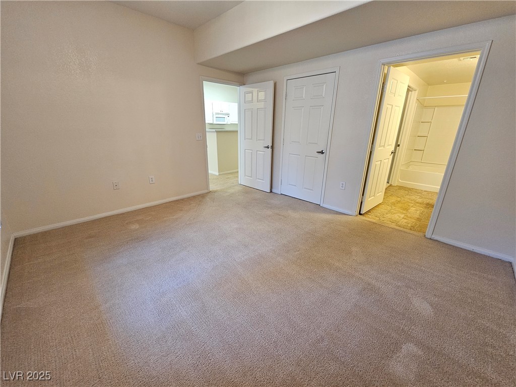 9000 South Las Vegas Boulevard, Unit 1176 Las Vegas, NV 89123 - Photo 20 of 26 Unfurnished bedroom with light colored carpet, ensuite bath, and a closet