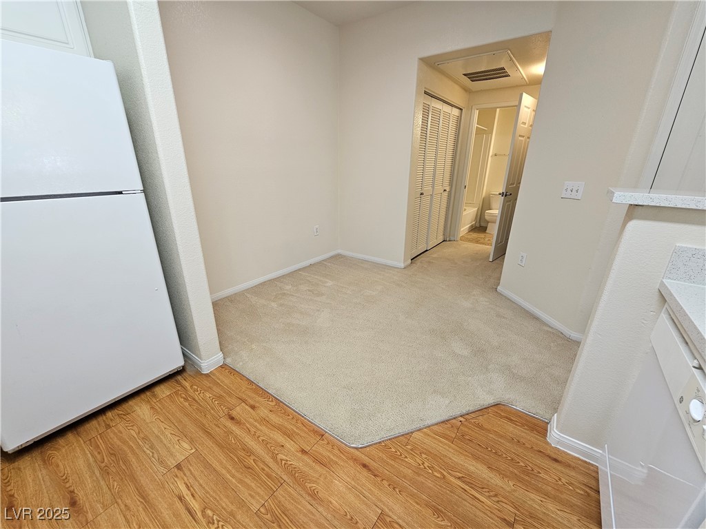 9000 South Las Vegas Boulevard, Unit 1176 Las Vegas, NV 89123 - Photo 9 of 26 Unfurnished dining area with light wood-style floors and light colored carpet