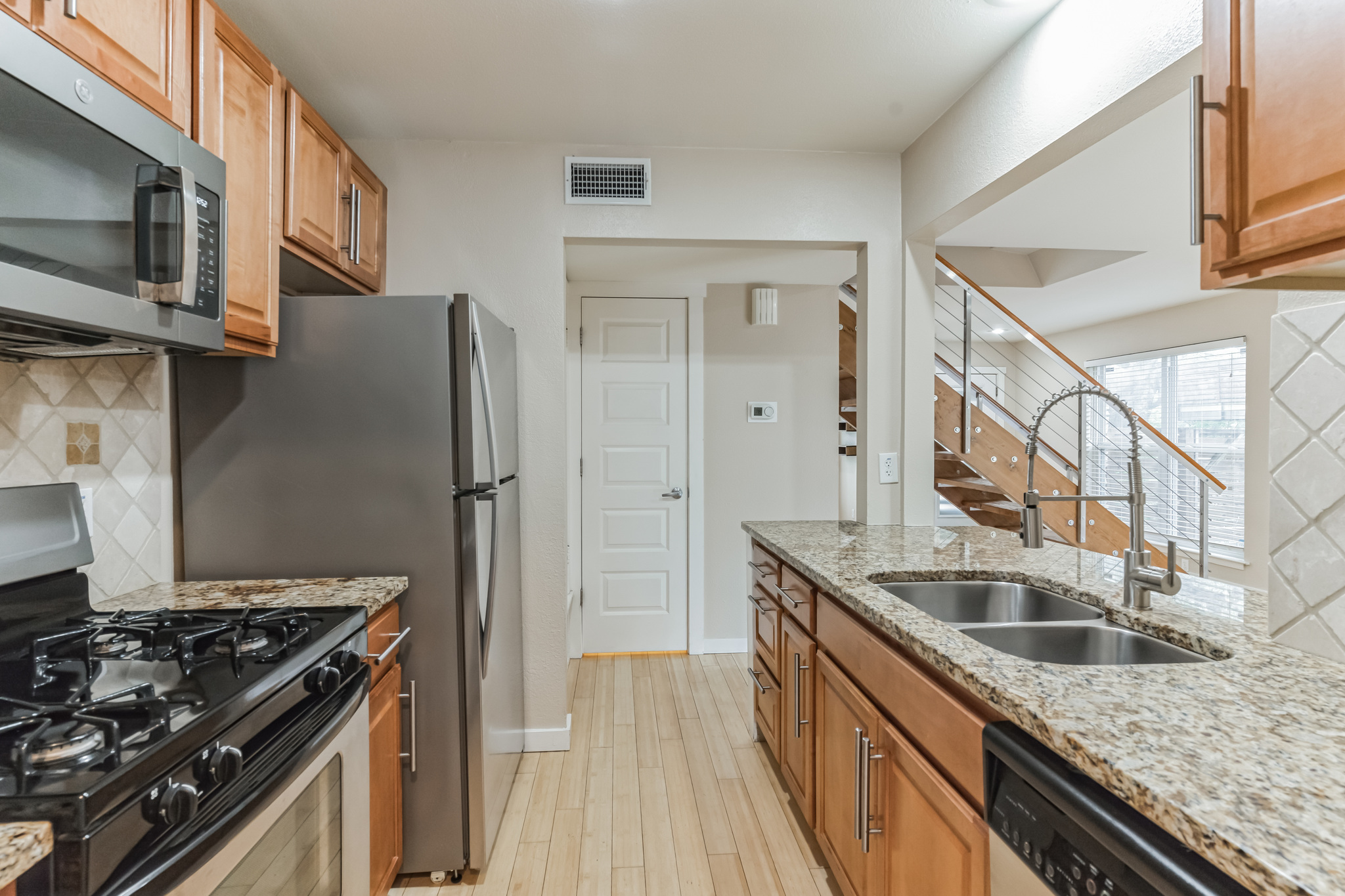 3214 Clawson Road, Unit A Austin, TX 78704 - Photo 6 of 26 Culinary delights await in this bright kitchen with granite countertops, sleek stainless steel appliances, and abundant cabinet storage.