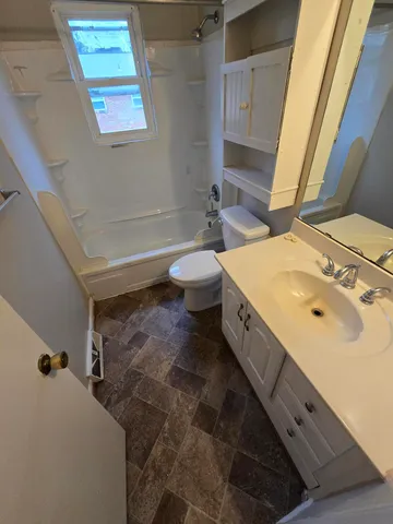 a bathroom with a double vanity sink toilet and a tub