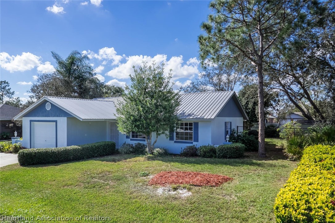 4115 Loquat Road Sebring, FL 33875 - Photo 1 of 28 a front view of a house with garden