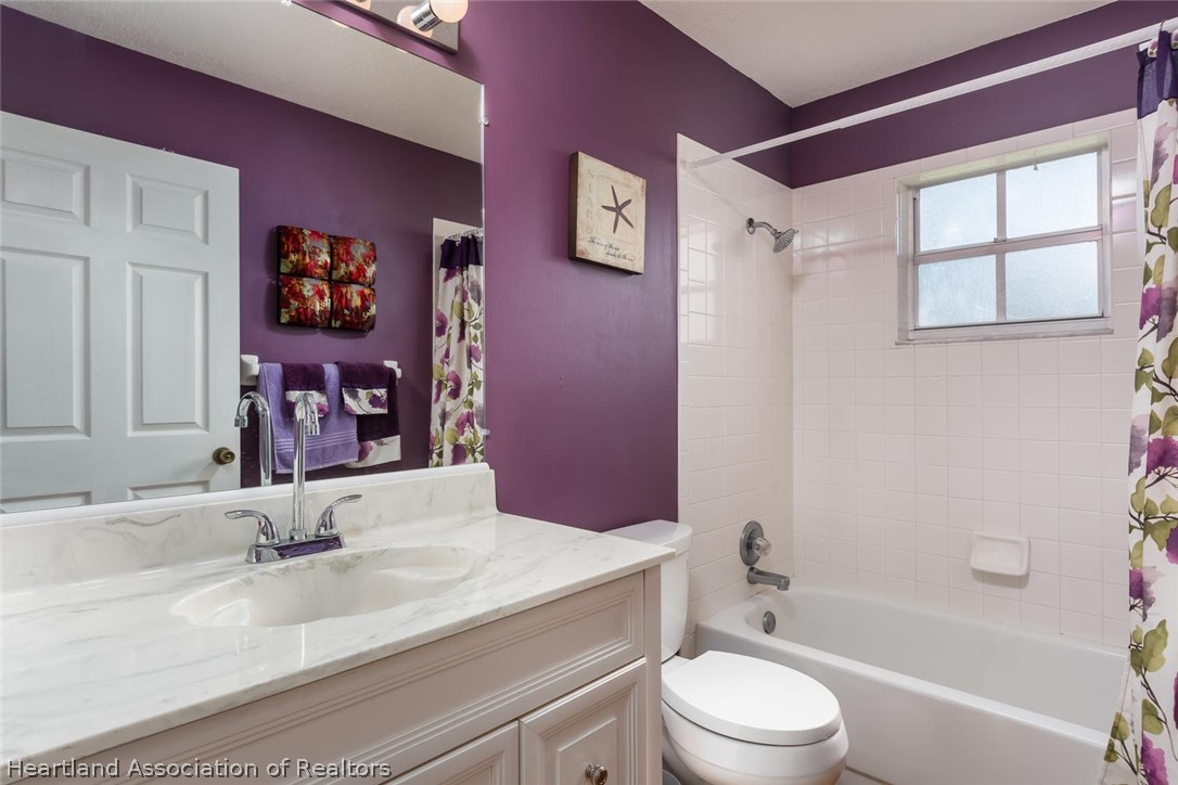 4115 Loquat Road Sebring, FL 33875 - Photo 11 of 28 a bathroom with a granite countertop sink toilet a large mirror and shower