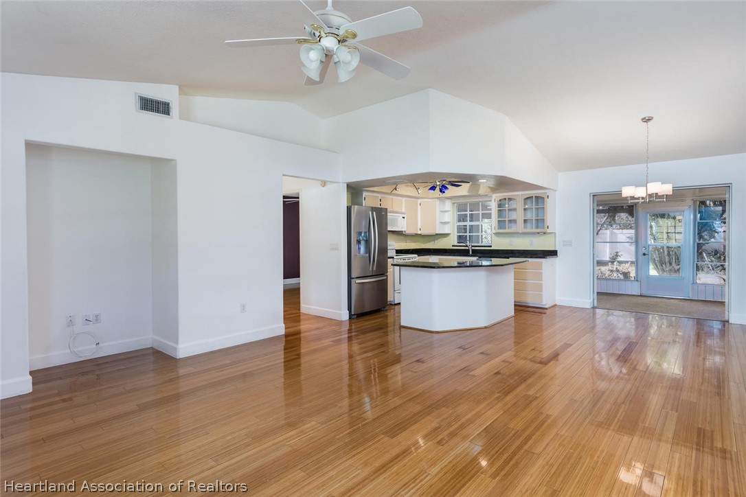 4115 Loquat Road Sebring, FL 33875 - Photo 2 of 28 a large kitchen with granite countertop a stove top oven a sink dishwasher and a refrigerator with wooden floor