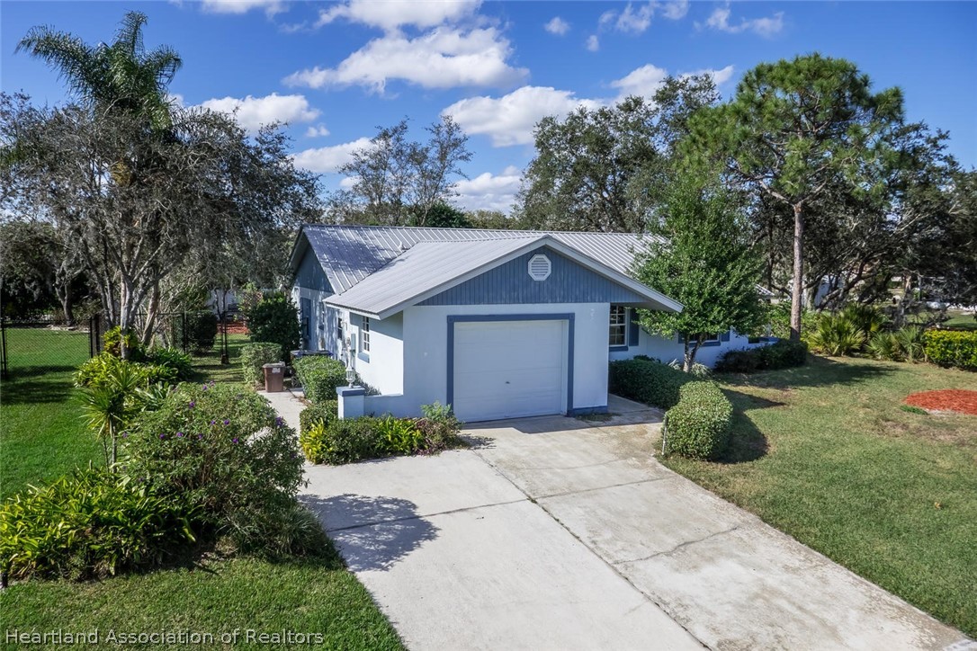 4115 Loquat Road Sebring, FL 33875 - Photo 26 of 28 a view of a house with a small yard plants and large tree