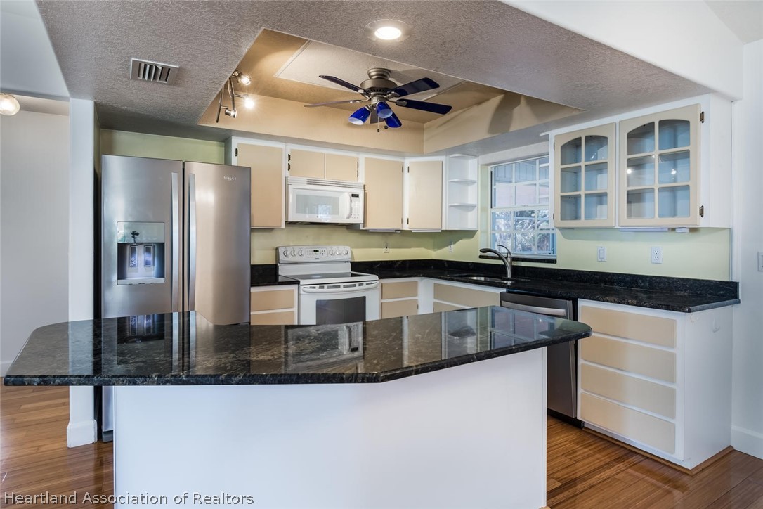 4115 Loquat Road Sebring, FL 33875 - Photo 3 of 28 a kitchen with stainless steel appliances granite countertop a sink a stove and a refrigerator