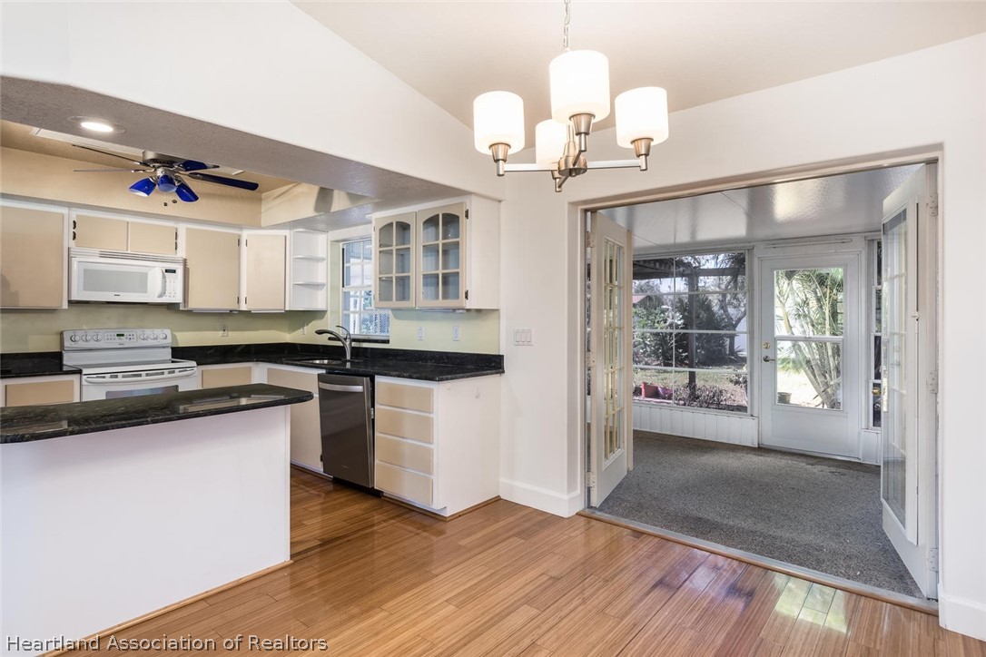 4115 Loquat Road Sebring, FL 33875 - Photo 6 of 28 a large kitchen with cabinets wooden floor and stainless steel appliances