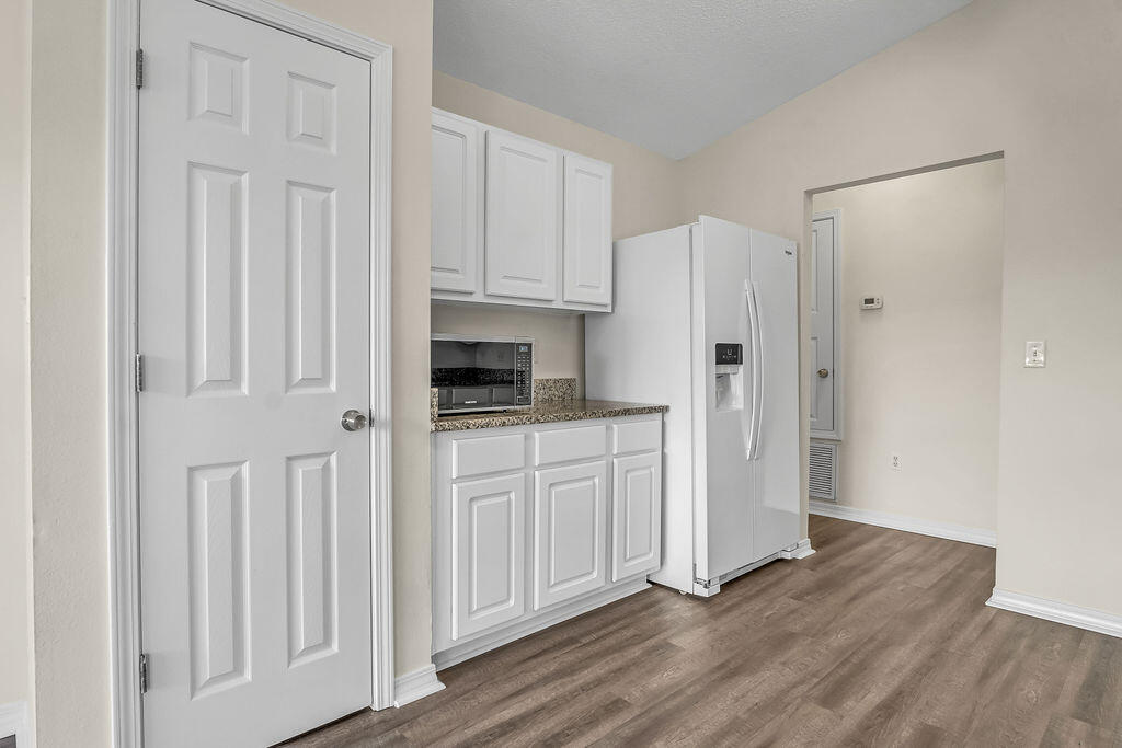 4641 Sunsail Circle Destin, FL 32541 - Photo 11 of 28 a kitchen with white cabinets and refrigerator