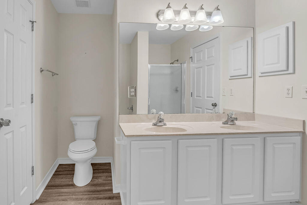 4641 Sunsail Circle Destin, FL 32541 - Photo 17 of 28 a bathroom with a granite countertop sink a toilet and a mirror