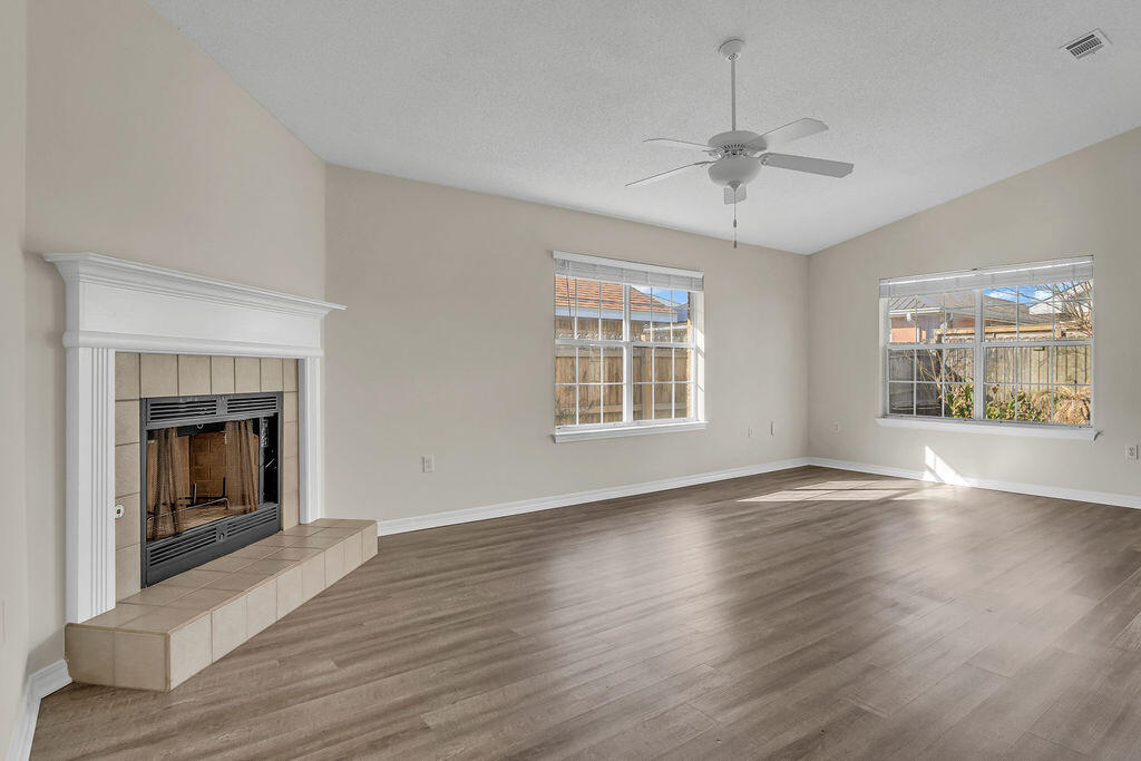 4641 Sunsail Circle Destin, FL 32541 - Photo 5 of 28 an empty room with wooden floor fireplace and windows