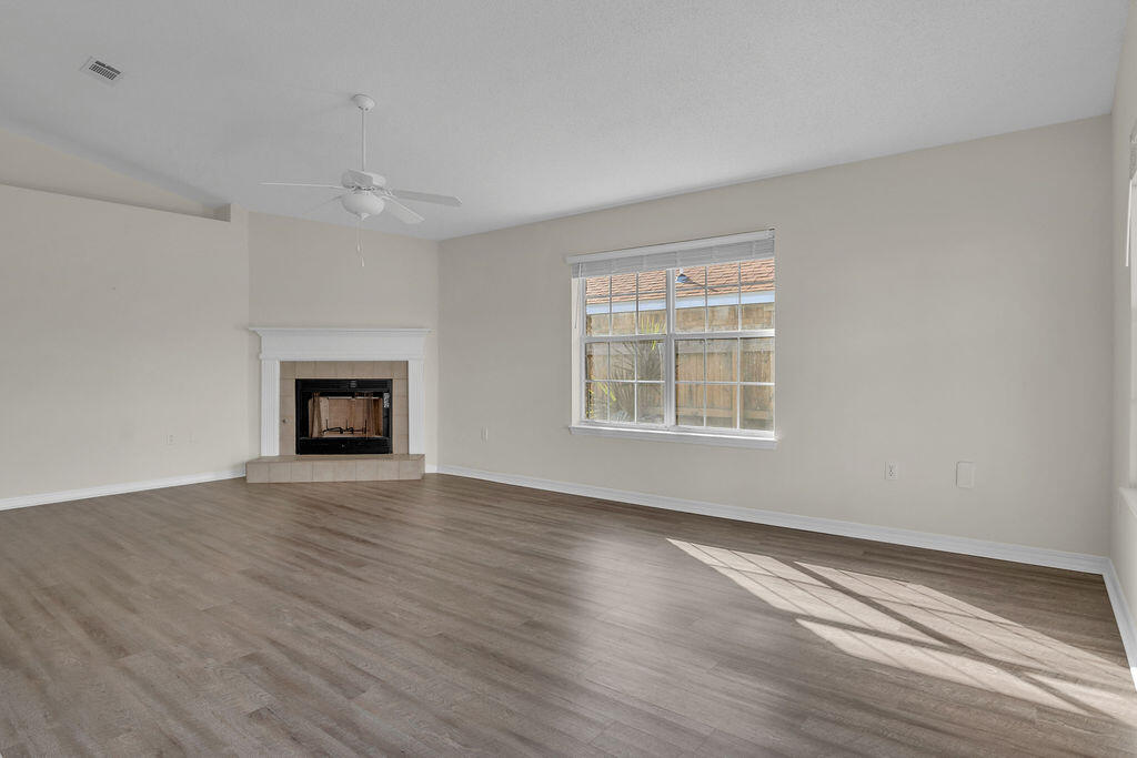 4641 Sunsail Circle Destin, FL 32541 - Photo 9 of 28 a view of an empty room with wooden floor fireplace and a window