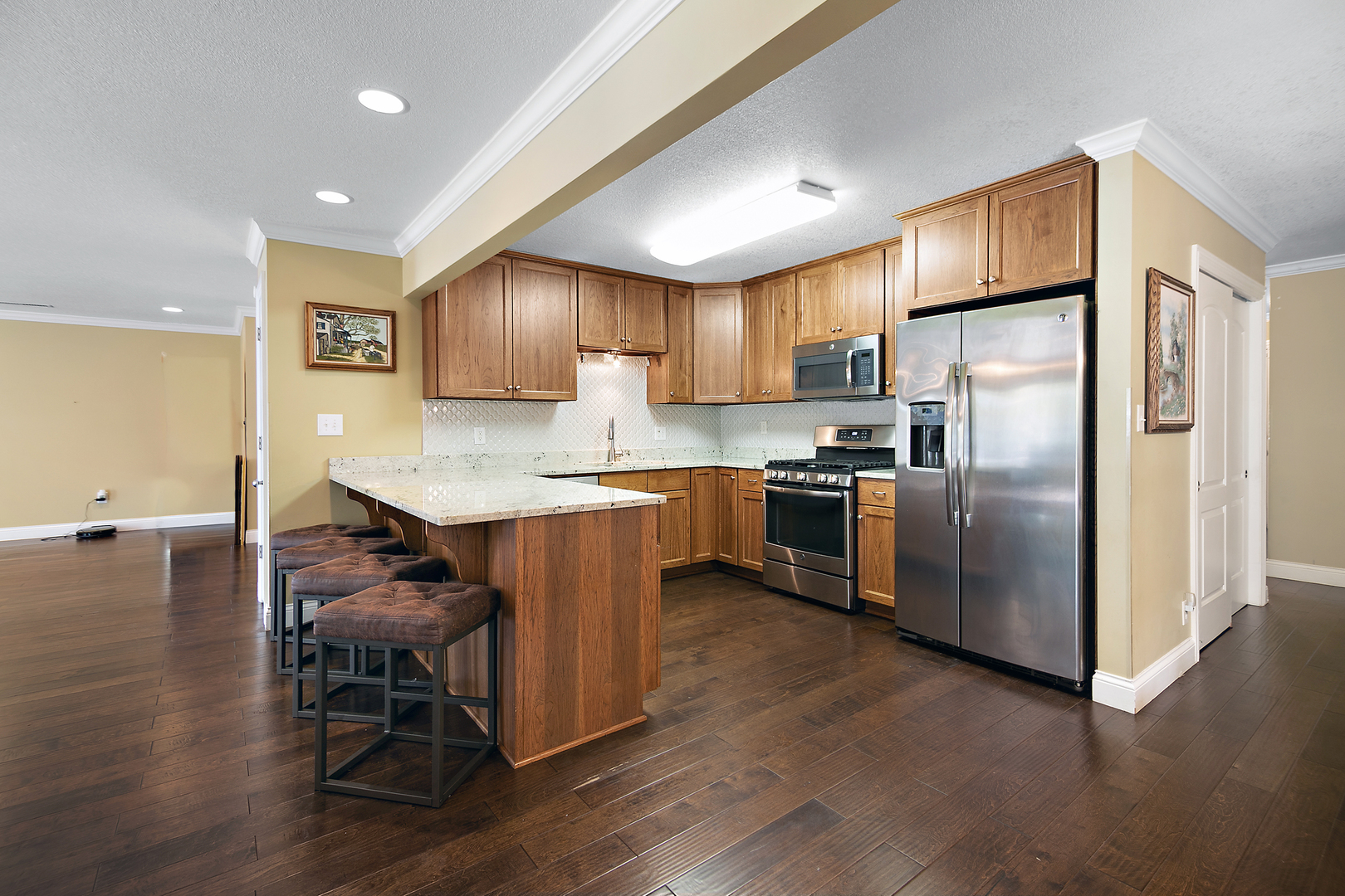 1305 Oaktree Lane Kankakee, IL 60901 - Photo 13 of 47 a kitchen with stainless steel appliances granite countertop a refrigerator a stove a sink a dining table and chairs with wooden floor