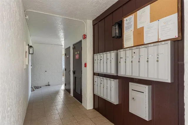 a view of a hallway with white walls and stairs