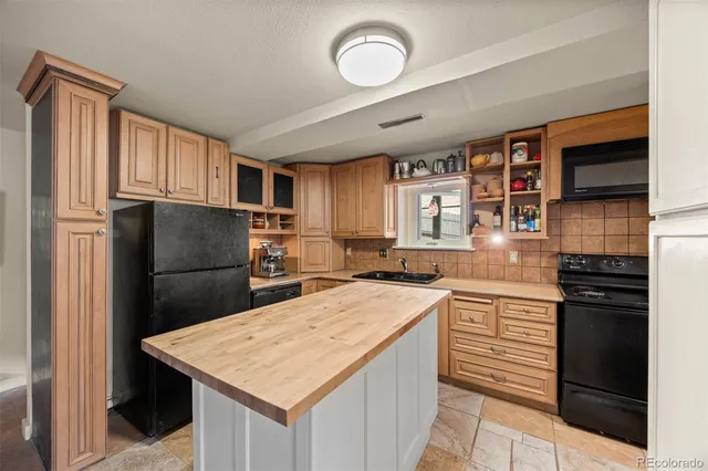 a kitchen with stainless steel appliances granite countertop a refrigerator a stove and a sink