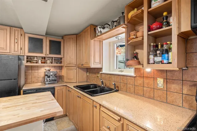 a kitchen with a sink a stove a refrigerator and cabinetry