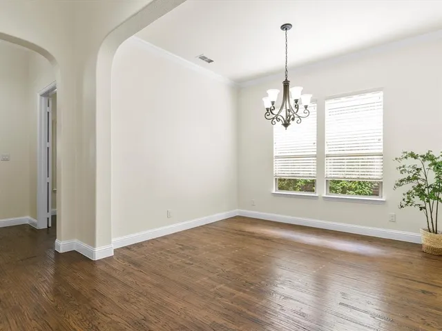 a view of a room with wooden floor chandelier and a window