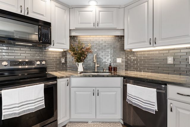 a kitchen with cabinets stainless steel appliances and sink