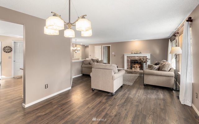 a living room with fireplace furniture and a wooden floor