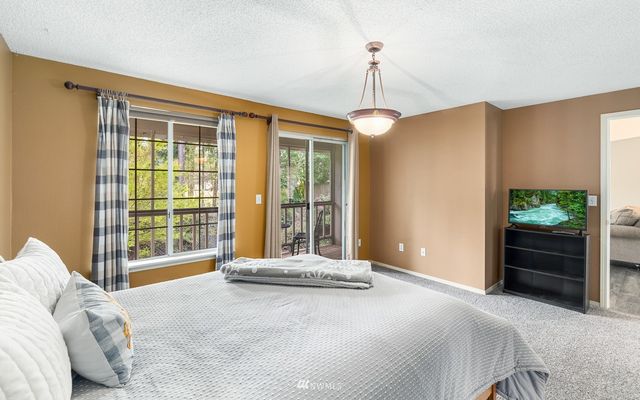 a spacious bedroom with a bed and a chandelier