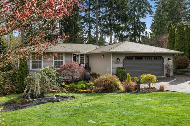 a front view of a house with a garden and plants