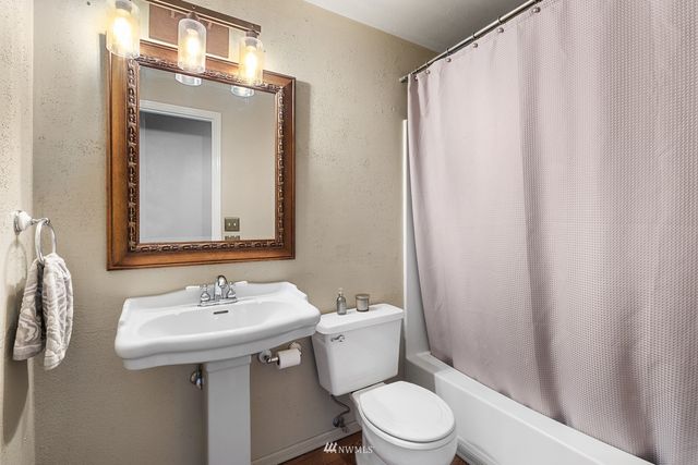 a bathroom with a sink a toilet and mirror