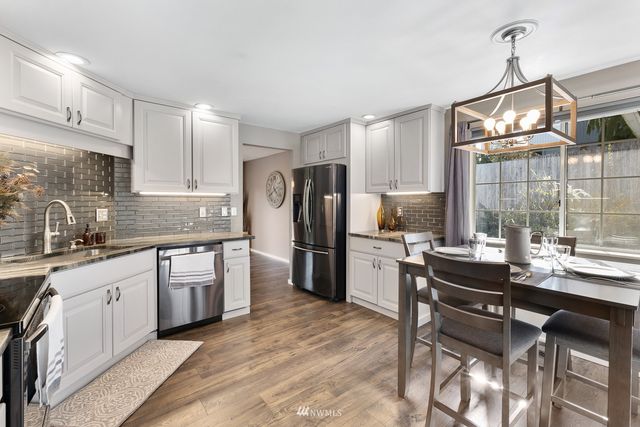 a kitchen with stainless steel appliances granite countertop a sink and cabinets
