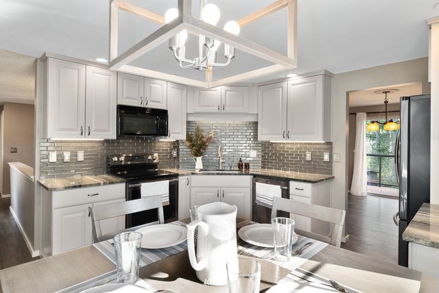 a kitchen with stainless steel appliances kitchen island granite countertop a sink and cabinets